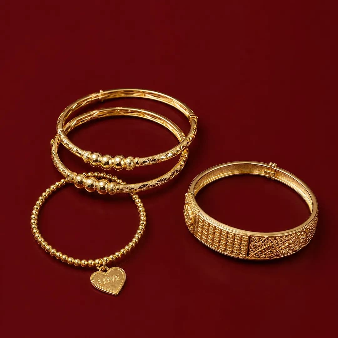 Four gold bangles, one with a heart charm